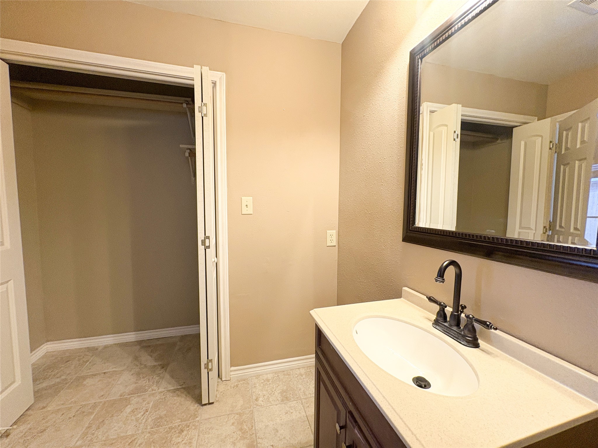 4503 Rattan Avenue Bay City, TX 77414 - Photo 12 of 14 Elegant bathroom with a sleek vanity, large mirror, and convenient access to a spacious closet.