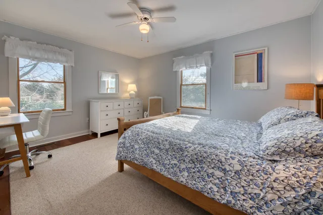 a bedroom with a bed a chandelier and a window