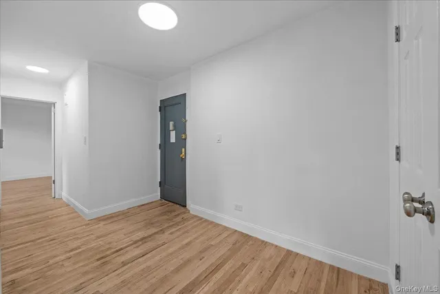 a view of an empty room with wooden floor and closet