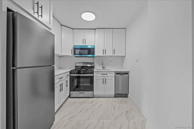 a kitchen with stainless steel appliances a refrigerator stove and microwave