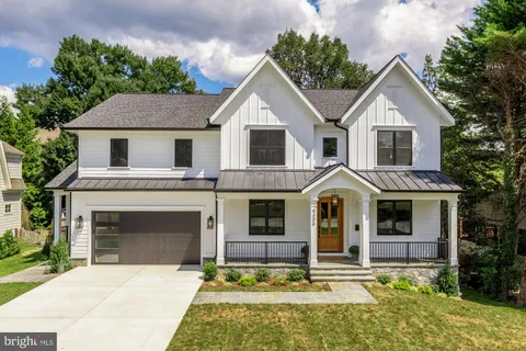 a front view of a house with yard and trees