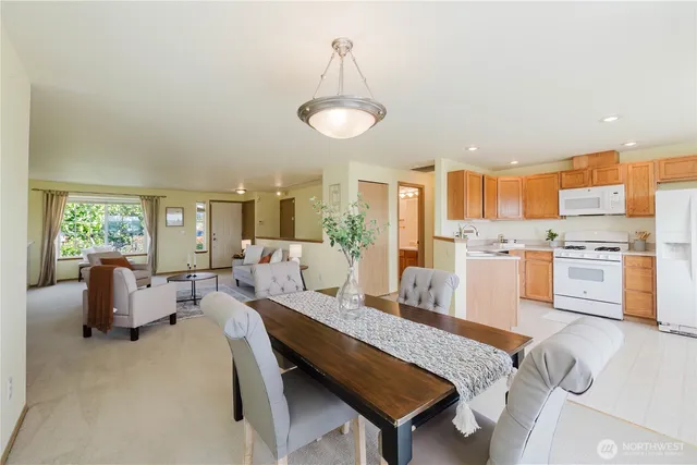 a living room with furniture kitchen view and a wooden floor