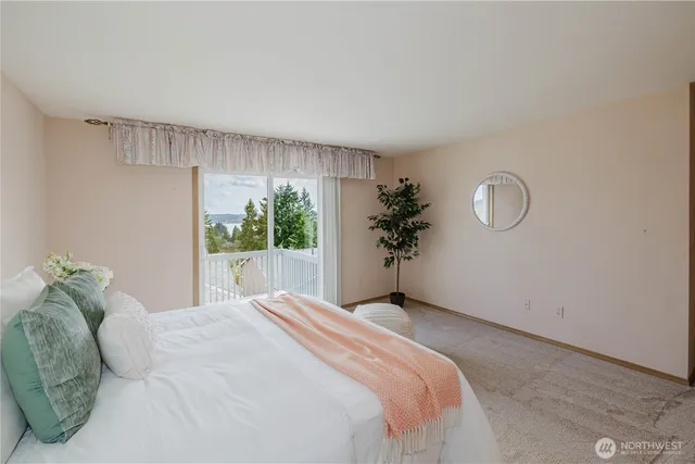 a bedroom with a large bed and a potted plant