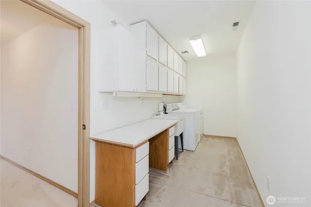 a utility room with cabinets washer and dryer