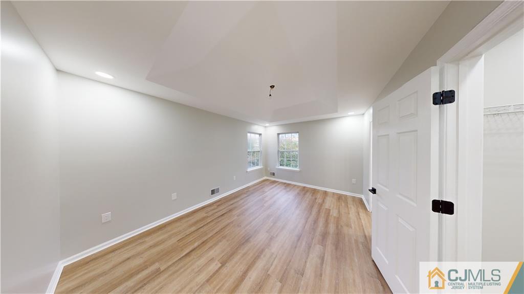2405 Timber Ridge Court, Unit 2405 Sayreville, NJ 08859 - Photo 13 of 29 a view of an empty room with wooden floor and a window