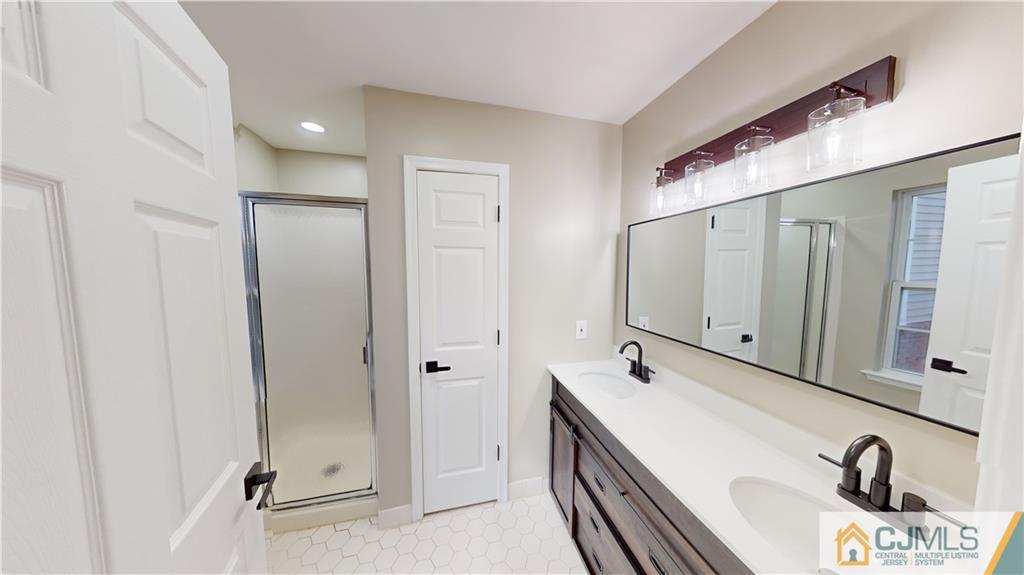 2405 Timber Ridge Court, Unit 2405 Sayreville, NJ 08859 - Photo 15 of 29 a bathroom with a double vanity sink a mirror and shower