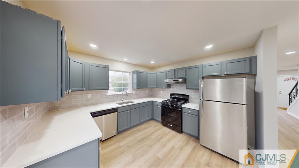 2405 Timber Ridge Court, Unit 2405 Sayreville, NJ 08859 - Photo 6 of 29 a kitchen with refrigerator a sink and white cabinets