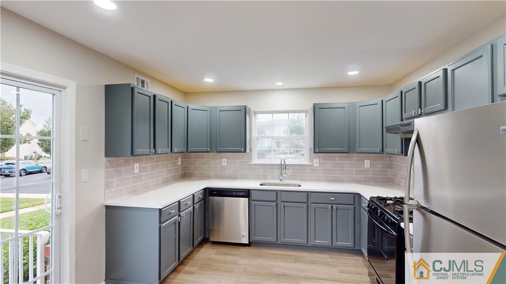 2405 Timber Ridge Court, Unit 2405 Sayreville, NJ 08859 - Photo 7 of 29 a kitchen with a sink a refrigerator and trees