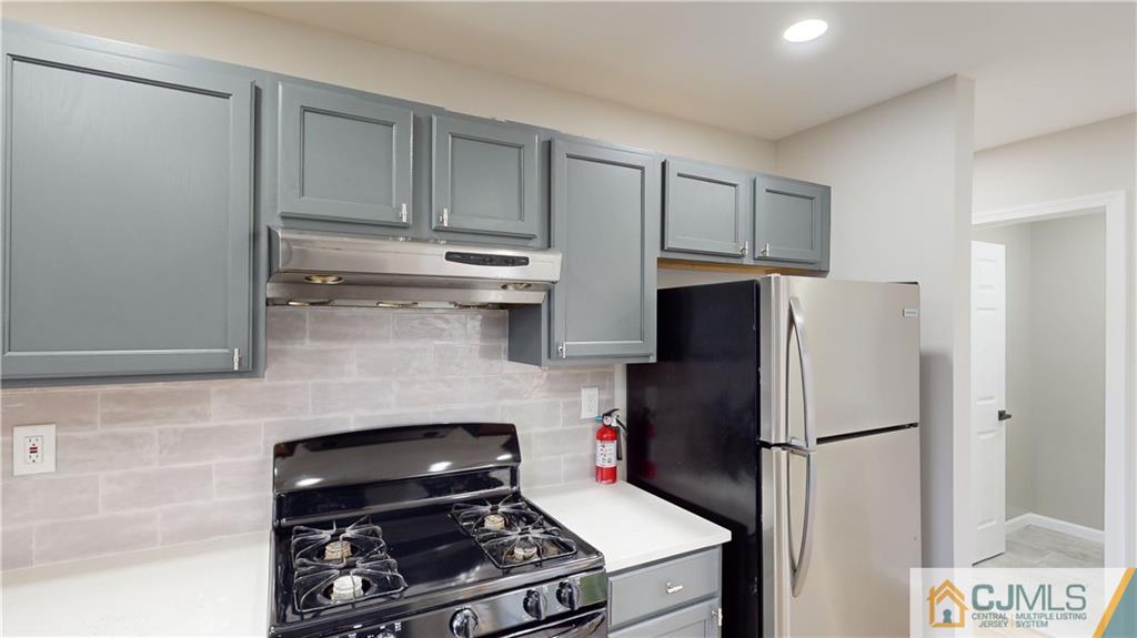2405 Timber Ridge Court, Unit 2405 Sayreville, NJ 08859 - Photo 8 of 29 a kitchen with a refrigerator stove and cabinets