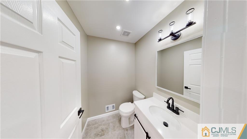2405 Timber Ridge Court, Unit 2405 Sayreville, NJ 08859 - Photo 10 of 29 a bathroom with a sink a toilet and mirror