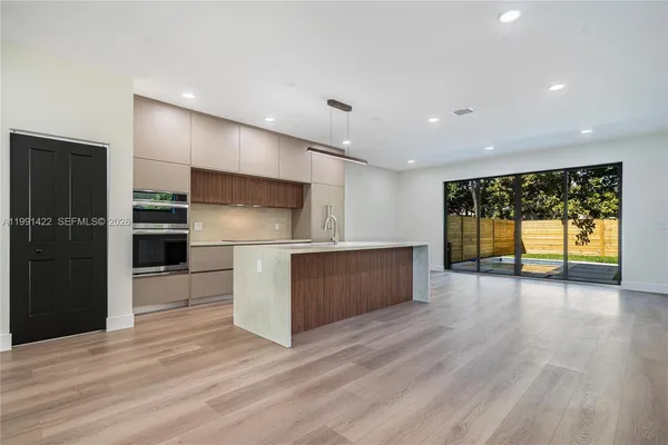 a kitchen with a wooden floor and a fireplace