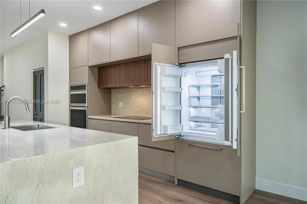a kitchen with a sink and large windows