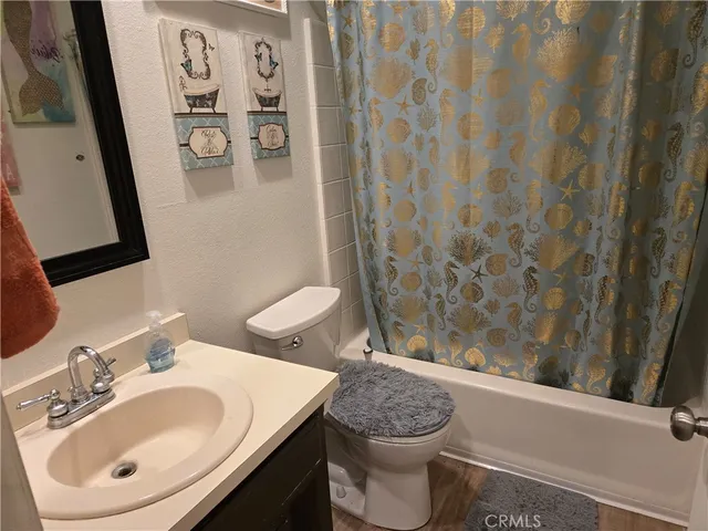 a bathroom with a sink a toilet and shower curtain