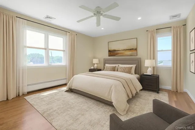 a bedroom with a large bed couch and windows