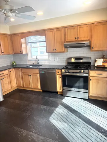 a kitchen with stainless steel appliances granite countertop a stove a sink and a microwave