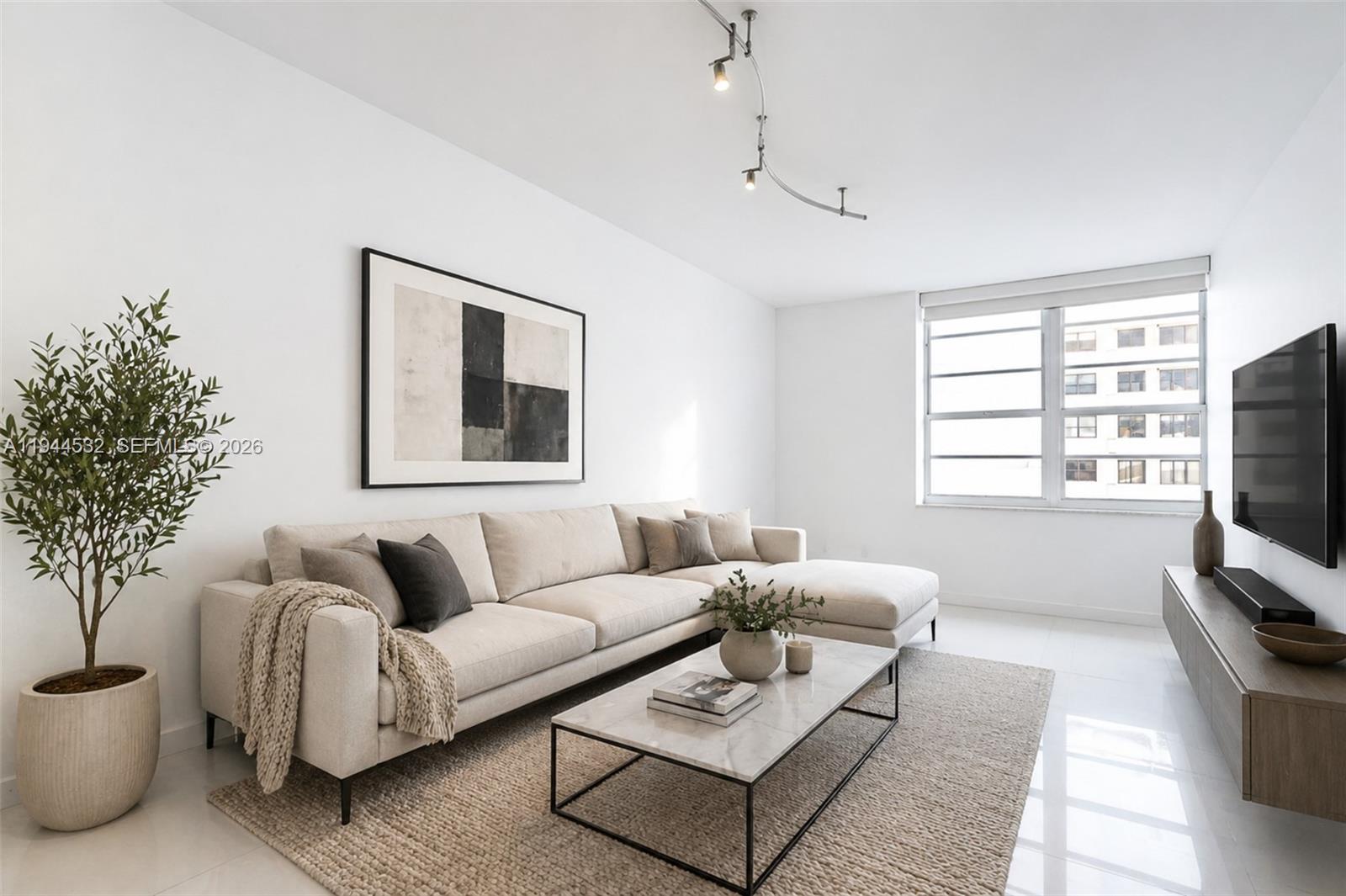 a living room with furniture a flat screen tv and a window