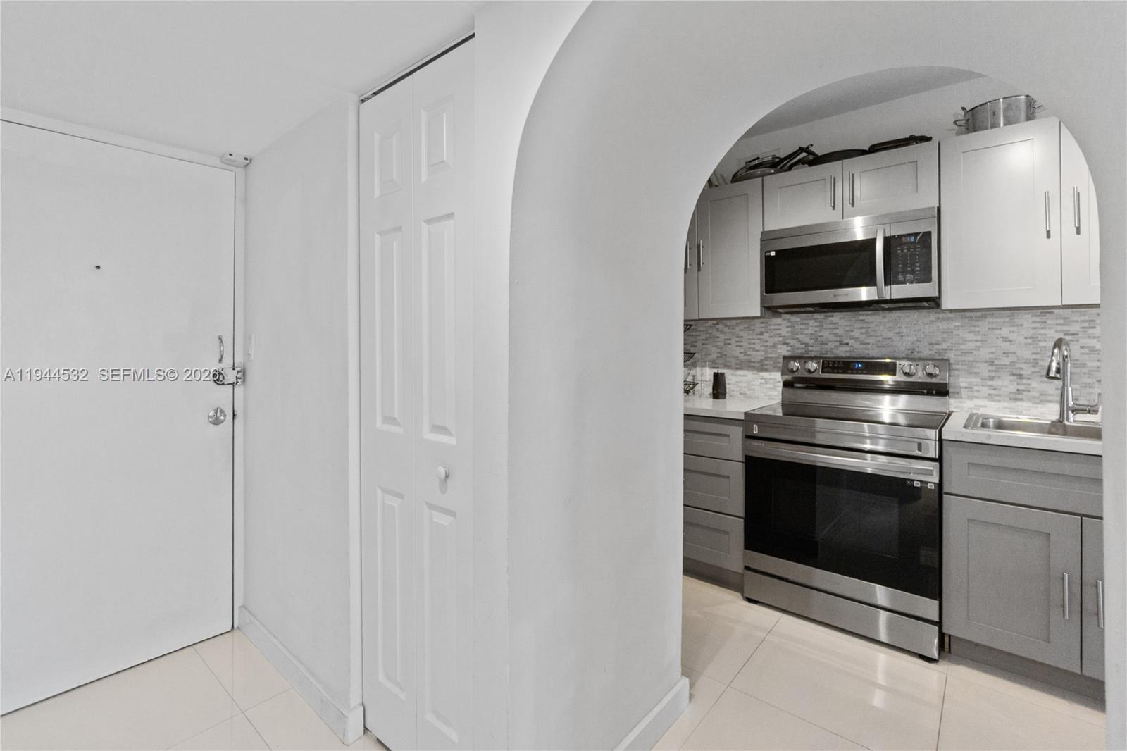 100 Lincoln Road, Unit 501 Miami Beach, FL 33139 - Photo 4 of 32 a kitchen with stainless steel appliances granite countertop a stove a microwave and a sink