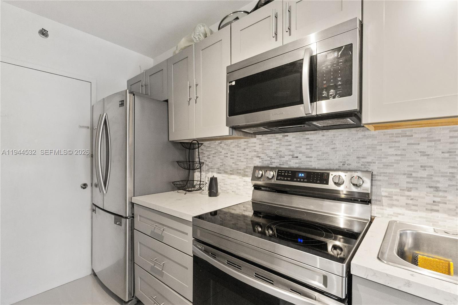 100 Lincoln Road, Unit 501 Miami Beach, FL 33139 - Photo 5 of 32 a kitchen with stainless steel appliances a stove microwave and sink