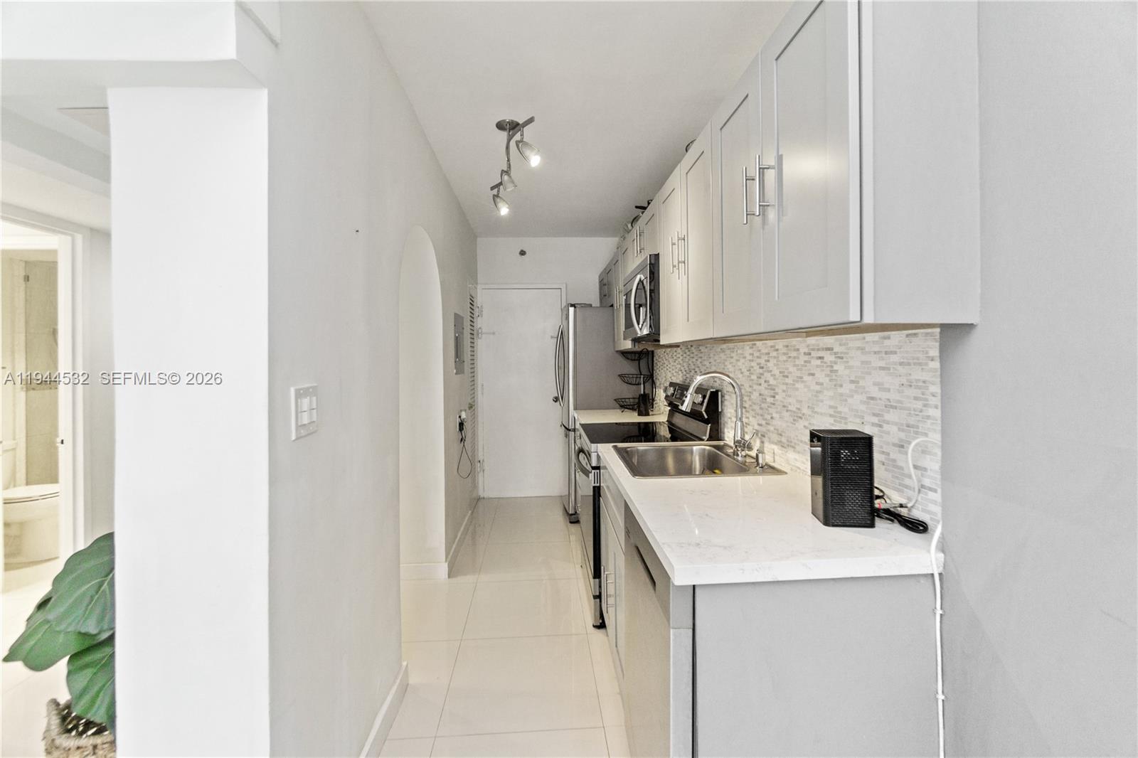 100 Lincoln Road, Unit 501 Miami Beach, FL 33139 - Photo 7 of 32 a kitchen with a sink a refrigerator and cabinets