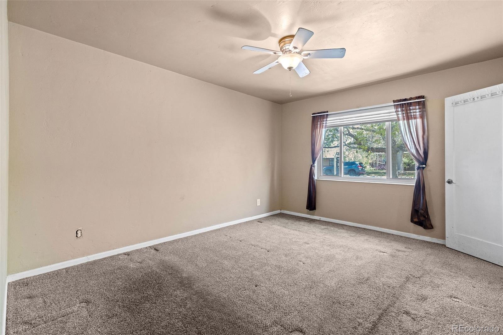 1283 Racine Street Aurora, CO 80011 - Photo 12 of 25 an empty room with windows and fan
