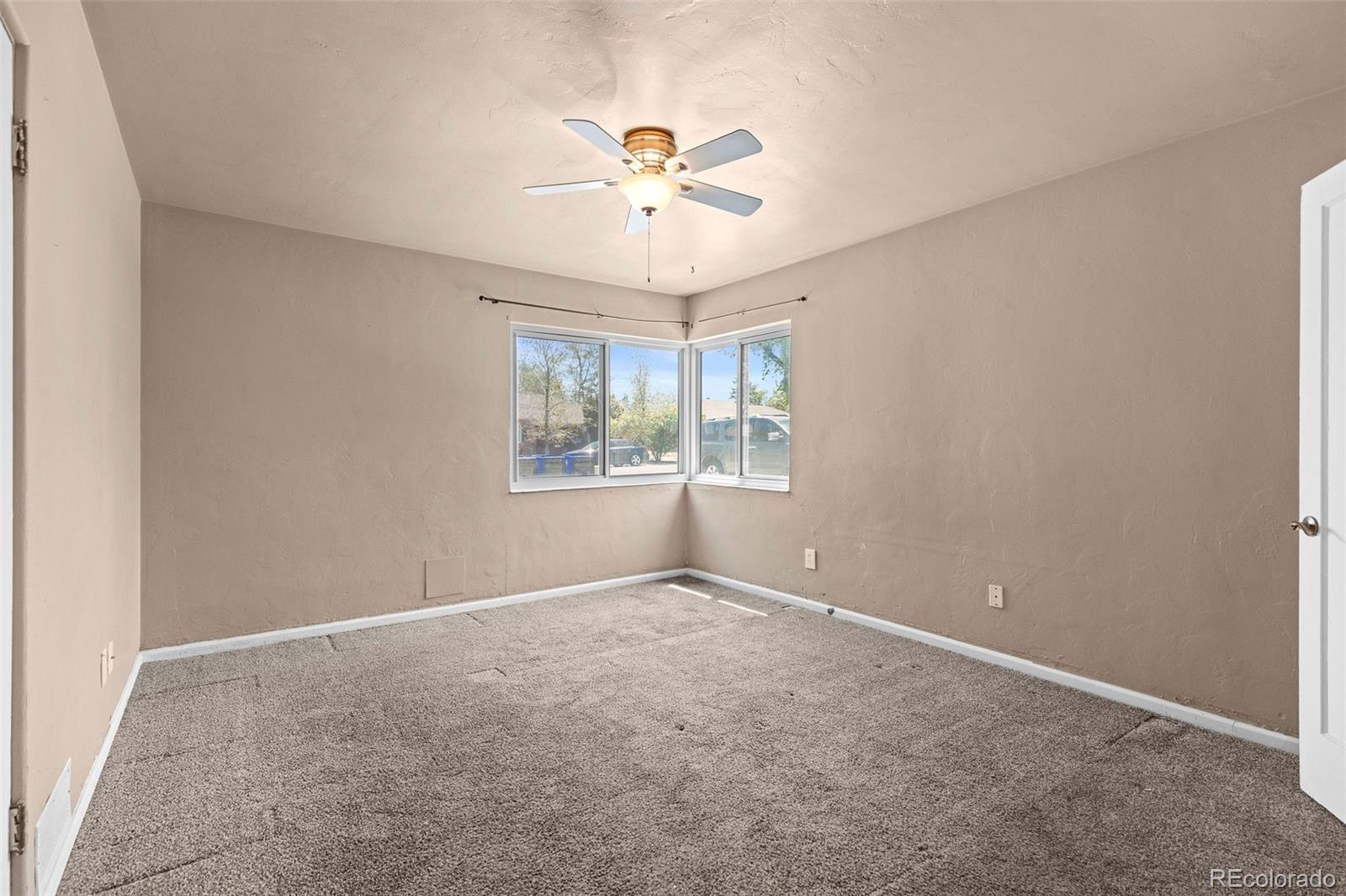 1283 Racine Street Aurora, CO 80011 - Photo 13 of 25 an empty room with windows and fan