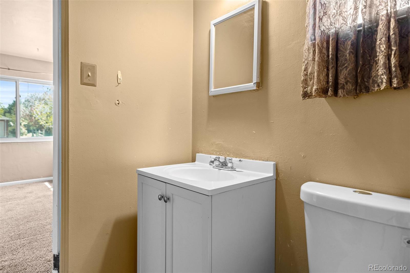 1283 Racine Street Aurora, CO 80011 - Photo 16 of 25 a bathroom with a sink and a toilet