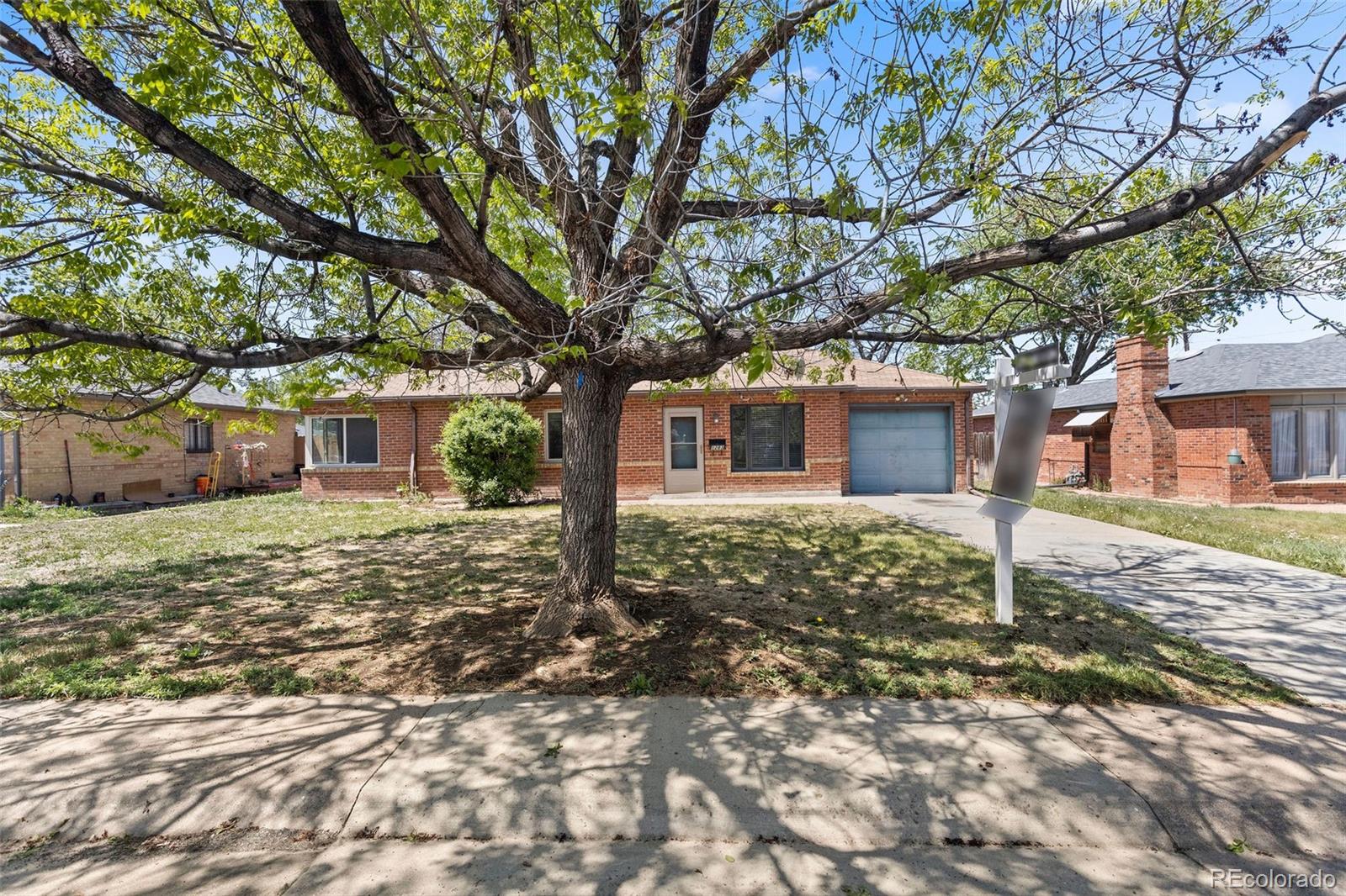 1283 Racine Street Aurora, CO 80011 - Photo 25 of 25 a tree in front of a white house
