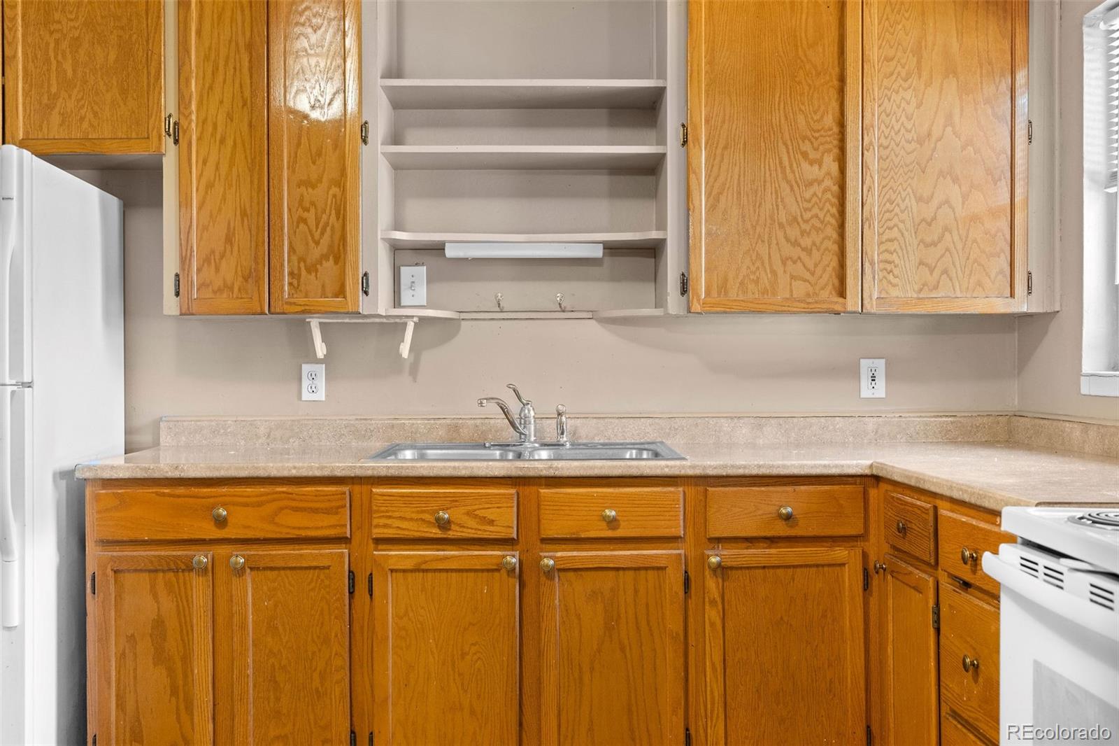 1283 Racine Street Aurora, CO 80011 - Photo 8 of 25 a kitchen with a refrigerator and cabinets