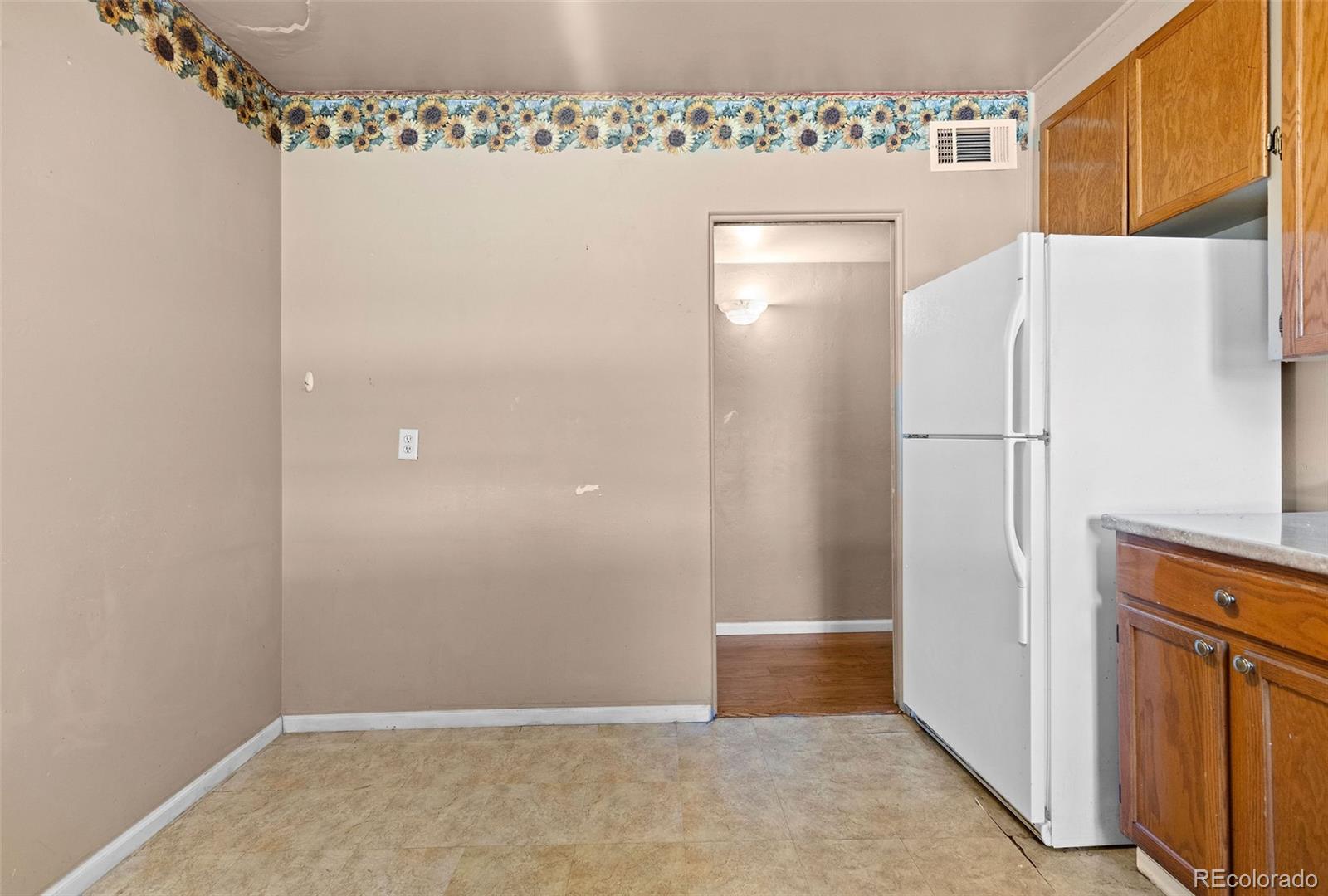 1283 Racine Street Aurora, CO 80011 - Photo 10 of 25 a view of a refrigerator in kitchen and white cabinets