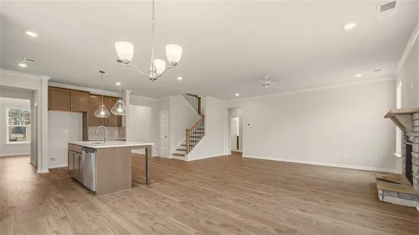 a view of a big room with wooden floor and windows
