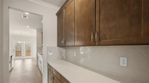 a view of a hallway with wooden floor and cabinets