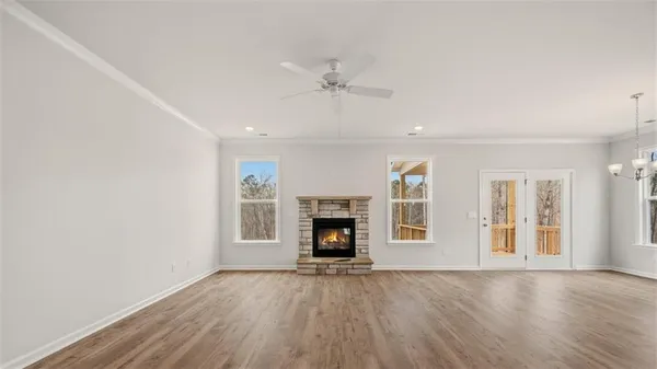 an empty room with fireplace cabinet and windows