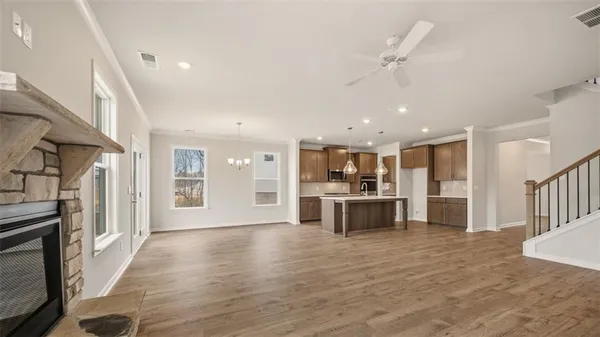a living room with stainless steel appliances kitchen island granite countertop a stove and a refrigerator