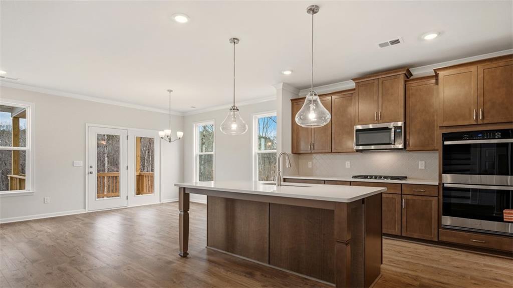 1908 Endress Circle Hampton, GA 30228 - Photo 2 of 35 a large kitchen with stainless steel appliances kitchen island granite countertop a stove a sink and a microwave