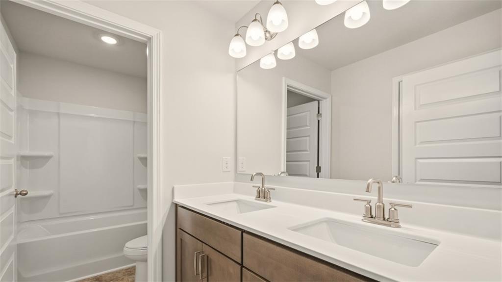 1908 Endress Circle Hampton, GA 30228 - Photo 23 of 35 a bathroom with a sink a toilet and a mirror