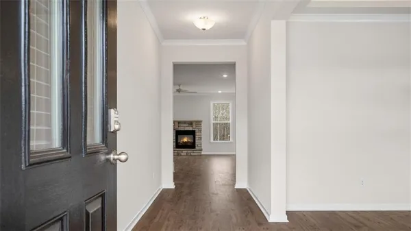 a view of a hallway with wooden floor and staircase