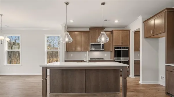 a kitchen with kitchen island granite countertop a sink cabinets and stainless steel appliances