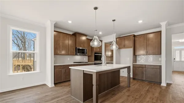a kitchen with kitchen island a sink stainless steel appliances and cabinets
