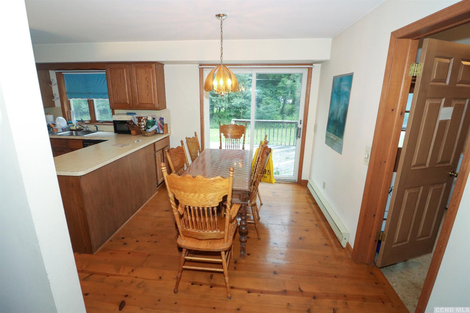 33 Viewmont Road Copake, NY 12516 - Photo 8 of 26 a dining room with furniture a rug a flat screen tv and a large window