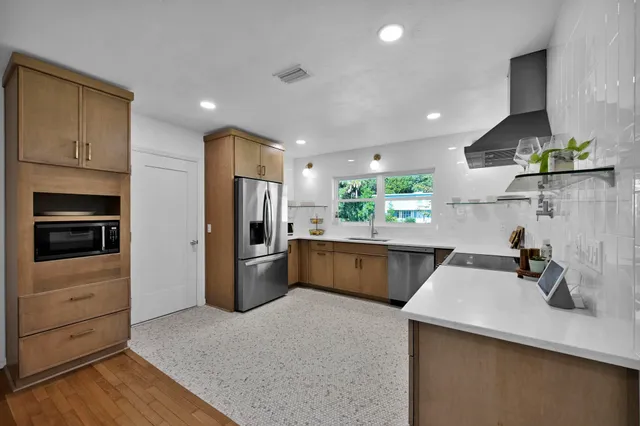 a kitchen with a sink a refrigerator and cabinets