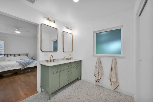 a en suite bathroom with a double vanity sink and a mirror