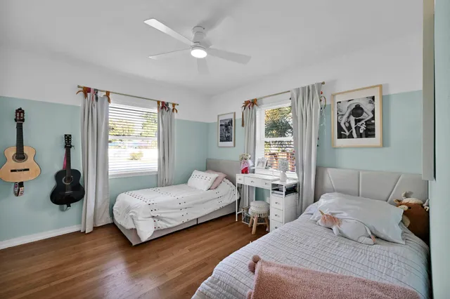 a bedroom with two beds and a large window