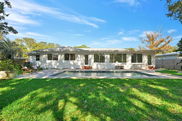 a view of a patio with table and chairs potted plants and large tree