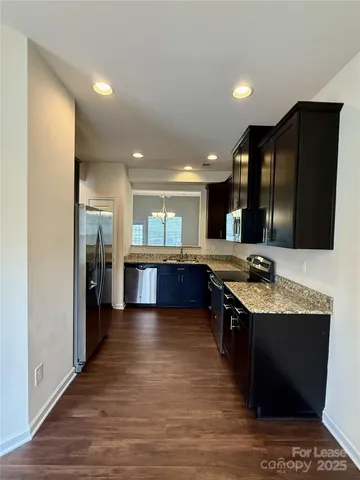 a kitchen with stainless steel appliances granite countertop a sink a stove and a refrigerator