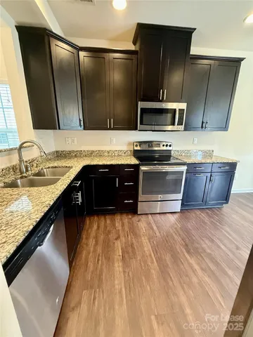a kitchen with stainless steel appliances granite countertop a sink and a stove