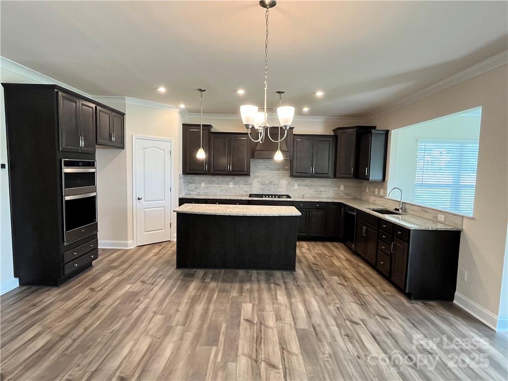 11506 Oakhampton Way Matthews, NC 28105 - Photo 12 of 27 a large kitchen with stainless steel appliances kitchen island granite countertop a large counter top a stove a sink cabinets and a wooden floor