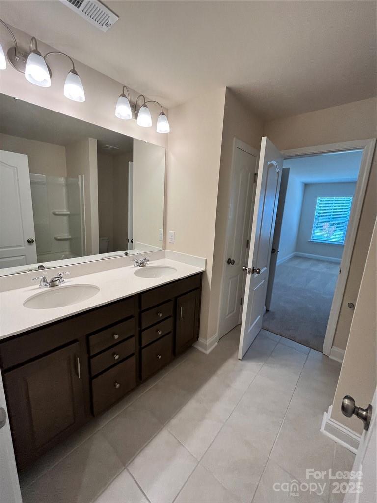 11506 Oakhampton Way Matthews, NC 28105 - Photo 22 of 27 a spacious bathroom with a double vanity sink a large mirror and a shower