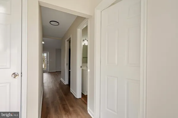 a view of a hallway with wooden floor