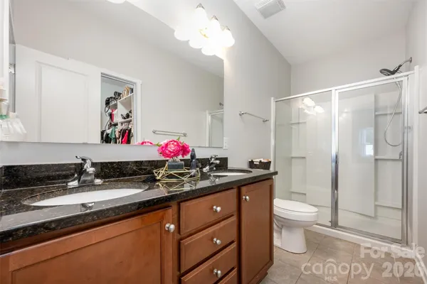 a bathroom with a granite countertop sink mirror vanity and toilet