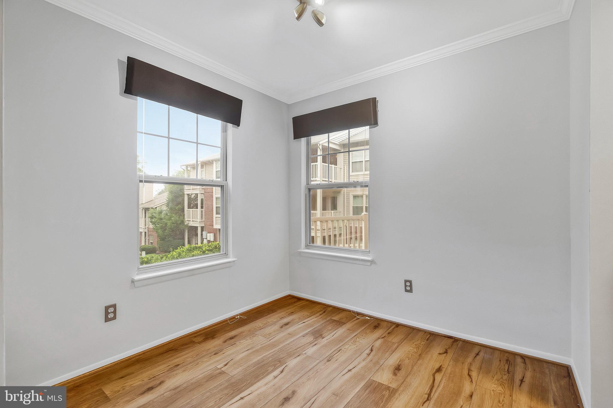 1701 Ascot Way, Unit 1701A Reston, VA 20190 - Photo 13 of 32 a view of an empty room with wooden floor and a window